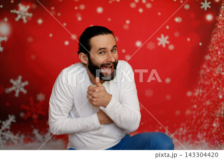 Laughing man showing thumbs up on Christmas background 143304420