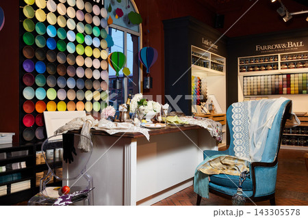 Colorful paint swatch wall interior design shop with fabrics textiles decor seating window lighting display featuring palettes circles colors and warm cozy showroom ambience Colorful paint swatch wall interior design shop with fabrics textiles decor seating window lighting display featuring palettes circles colors and warm cozy showroom ambience 143305578