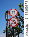 Urban street traffic signs showing bicycle allowed and scooter prohibited mounted on metal pole beside ornate street lamp against clear blue sky in daytime Urban street traffic signs showing bicycle allowed and scooter prohibited mounted on metal pole beside ornate street lamp against clear blue sky in daytime 143305673