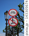 Circular traffic sign set on ornate lamppost: bicycle permitted above scooter prohibited, red and white symbols against clear blue sky Circular traffic sign set on ornate lamppost: bicycle permitted above scooter prohibited, red and white symbols against clear blue sky 143305674