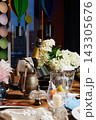 Champagne bottle in ornate metal chilled container with white hydrangeas and festive table setting, balloons and candlelight Champagne bottle in ornate metal chilled container with white hydrangeas and festive table setting, balloons and candlelight 143305676