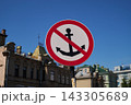 Prohibition traffic sign with crossed anchor symbol on rusty post along city street, clear blue sky and blurred historic buildings in background Prohibition traffic sign with crossed anchor symbol on rusty post along city street, clear blue sky and blurred historic buildings in background 143305689