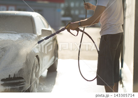 Worker washing car at self-service car wash Worker washing car at self-service car wash 143305714