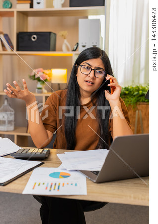 Indian woman on home table calls about billing error and discusses wrong charge on receipt by phone Indian woman on home table calls about billing error and discusses wrong charge on receipt by phone 143306428