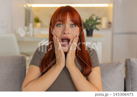 Young woman grabs cheeks and shouts wow happily surprised by good news joyful reaction big smile yay Young woman grabs cheeks and shouts wow happily surprised by good news joyful reaction big smile yay 143306475