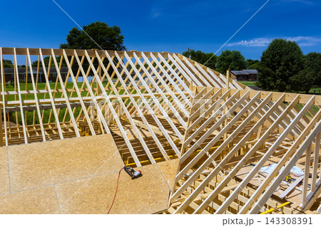 Workers build wooden frame structure with complex roof design 143308391