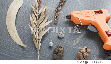 Orange glue gun dry plants decoration craft background. Hot melt adhesive tool hobby creative activity. DIY home decor handmade autumn style project workshop. Orange glue gun dry plants decoration craft background. Hot melt adhesive tool hobby creative activity. DIY home decor handmade autumn style project workshop. 143308629