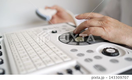 Doctor hand operating ultrasound machine control panel, medical diagnostic procedure Doctor hand operating ultrasound machine control panel, medical diagnostic procedure 143309707