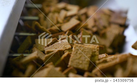 Close up of brown bread croutons on factory production line Close up of brown bread croutons on factory production line 143309756