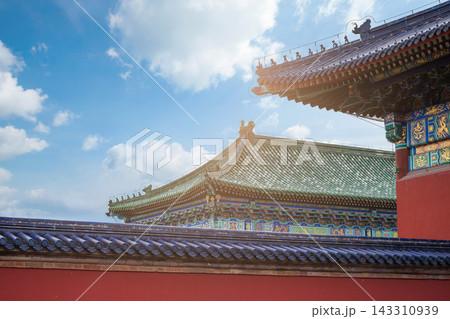 Traditional Chinese Architecture with Ornate Roof and Red Wall Under Blue Sky 143310939