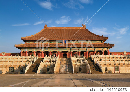 The Forbidden City in Beijing, China, with its iconic red walls and golden roofs under a clear blue sky 143310978