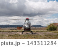 Helicopter parked on landing pad in rural landscape 143311284