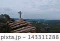 Christian cross on mountain peak with valley view 143311288