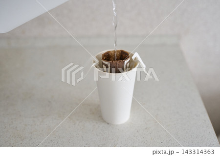 Paper Cup Drip Coffee Filter Being Filled With Water From Kettle On Speckled Countertop In Neutral 143314363