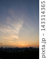 Colorful Sunset Sky Glowing Above Dark City Skyline With Wispy Clouds Over Distant Buildings 143314365