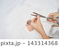 Hands Trimming Numbered Paper Measuring Strip Beside Wrapped Pattern Roll On White Treatment Bed 143314368