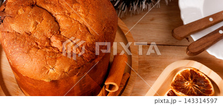 Classic panettone with candied fruit on a decorated table during Christmas celebrations. Classic panettone with candied fruit on a decorated table during Christmas celebrations. 143314597