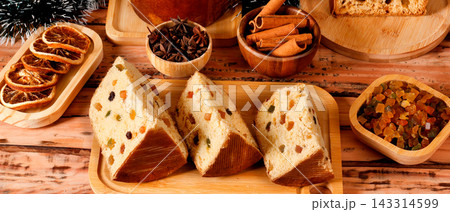 Slices of classic panettone showing delicate dough, candied fruit and raisins in a festive Christmas arrangement. Slices of classic panettone showing delicate dough, candied fruit and raisins in a festive Christmas arrangement. 143314599