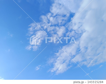 Rich blue sky with scattered white clouds. Bright sunny day weather background Rich blue sky with scattered white clouds. Bright sunny day weather background 143315284