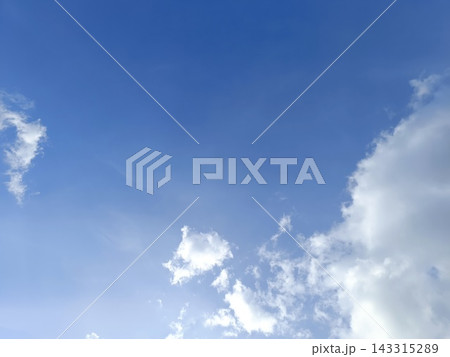 Bright blue sky featuring fluffy white clouds. Daytime weather background with natural light Bright blue sky featuring fluffy white clouds. Daytime weather background with natural light 143315289