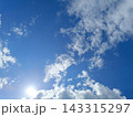 Bright sun shining in a blue sky with white clouds. Sunny summer day background 143315297