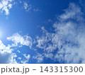 Clear blue sky with wispy white clouds. Sunny day weather background 143315300