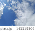 Bright blue sky with fluffy white clouds. Natural background of sunny weather 143315309