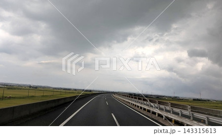 曇り空の田園地帯をカーブする高速道路 143315613