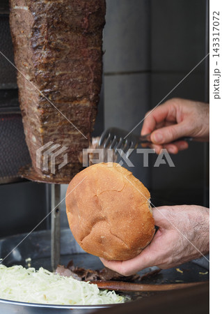 Activity of preparing a sandwich with meat at a food stall 143317072