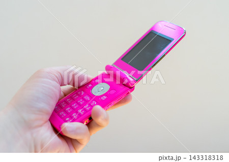 ピンク色のガラケーを持つ ピンク色のガラケーを持つ 143318318