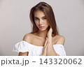 Young woman in stylish dress looks at camera in studio 143320062