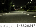 街灯の光が照らす夜の三車線道路、静かな雰囲気が広がる車道と奥行きのある風景 143320847