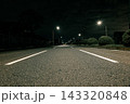 街灯の光が照らす夜の三車線道路、静かな雰囲気が広がる車道と奥行きのある風景 143320848