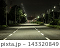 街灯の光が照らす夜の三車線道路、静かな雰囲気が広がる車道と奥行きのある風景 143320849