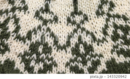 Knitted round yoke with a jacquard pattern in white and green yarn on wood Knitted round yoke with a jacquard pattern in white and green yarn on wood 143320942