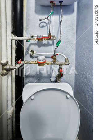 Water meter assembly includes brass utility valves and flexible hoses connected directly to domestic storage water heater installed inside residential room. Water meter assembly includes brass utility valves and flexible hoses connected directly to domestic storage water heater installed inside residential room. 143320945