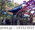 秋の紅葉に彩られた山寺の伝統的な木造建築と瓦屋根、石垣や石碑が残る日本の寺院風景 143321655