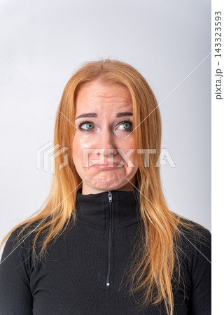 Young woman with red hair expressing emotions of sadness, worry, and distress, looking up with a pained facial expression, isolating on a plain white background Young woman with red hair expressing emotions of sadness, worry, and distress, looking up with a pained facial expression, isolating on a plain white background 143323593