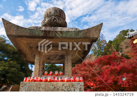 Daruma doll figures on stone lantern in Katsuo-ji temple at fall, Osaka 143324719