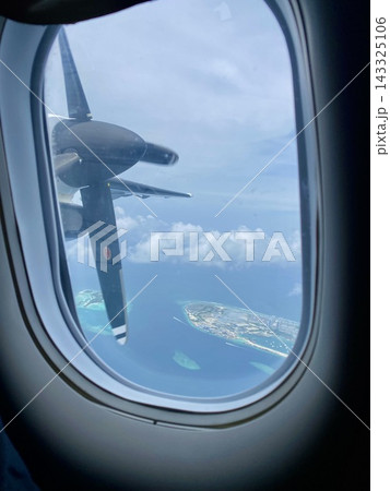 Turboprop airplane propeller above tropical islands viewed through cabin window. Turboprop airplane propeller above tropical islands viewed through cabin window. 143325106
