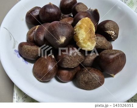 Fresh chestnuts with their glossy brown shells, ready to roast or cook. A seasonal favorite with a rich, slightly sweet flavor, perfect for cozy autumn dishes and festive treats. Fresh chestnuts with their glossy brown shells, ready to roast or cook. A seasonal favorite with a rich, slightly sweet flavor, perfect for cozy autumn dishes and festive treats. 143326351