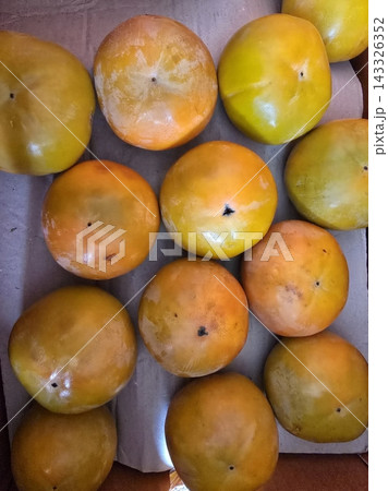 Fresh persimmon slices with vibrant orange color and smooth texture, showcasing their natural sweetness and juicy flesh, neatly arranged to highlight their simple and appealing appearance 143326352
