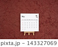 May 2027 calendar on red crumpled paper background. Directly above. 143327069