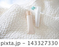 白いキルティング生地とスキンケア用品。自然光。 143327330