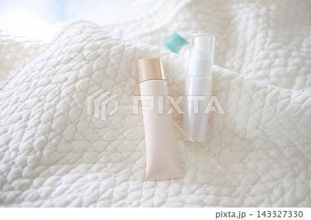 白いキルティング生地とスキンケア用品。自然光。 143327330