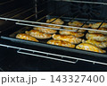 Freshly baked empanadas cooling on multiple oven racks with golden crispy tops 143327400