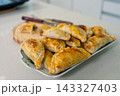 Warm golden empanadas arranged on a decorative ceramic plate 143327403
