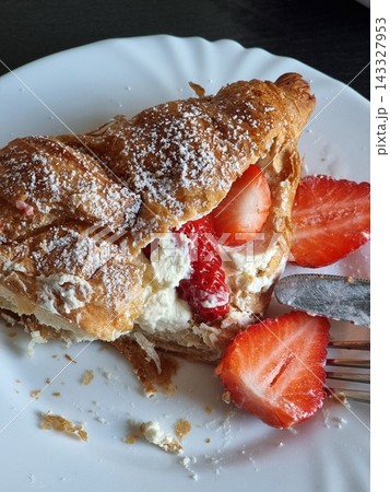 Buttery croissant filled with fresh fruits and whipped cream, offering a perfect mix of crisp, flaky layers and sweet, refreshing flavors in every delightful, elegant bite. Buttery croissant filled with fresh fruits and whipped cream, offering a perfect mix of crisp, flaky layers and sweet, refreshing flavors in every delightful, elegant bite. 143327953
