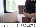 カウチソファに座って話す女性。窓際の明るい部屋。 143328075