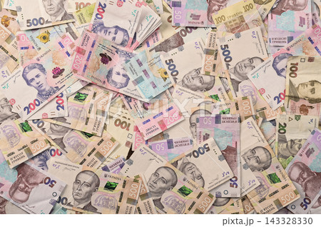 Ukrainian currency paper bills spread across background flat lay view. Ukrainian currency paper bills spread across background flat lay view. 143328330